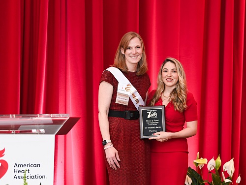 Two women on stage holding an award plaque